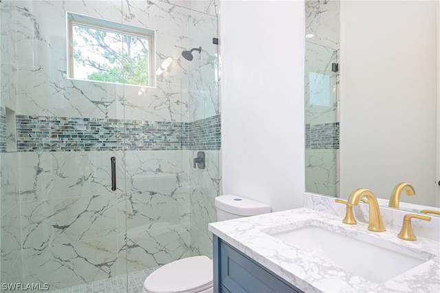 bathroom with vanity, toilet, and a shower with shower door