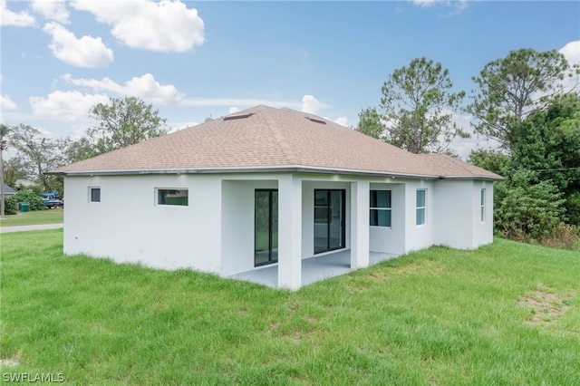 back of house featuring a lawn and a patio area