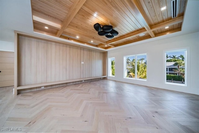 empty room featuring wood ceiling, beamed ceiling, and ceiling fan