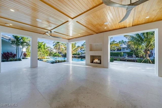 view of patio / terrace with a warm lit fireplace and ceiling fan