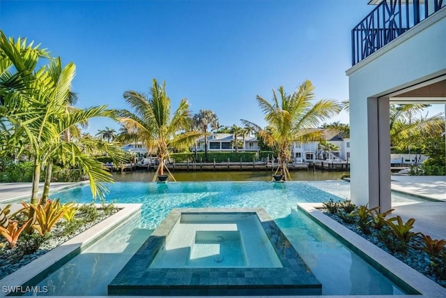 view of pool featuring a water view and a pool with connected hot tub
