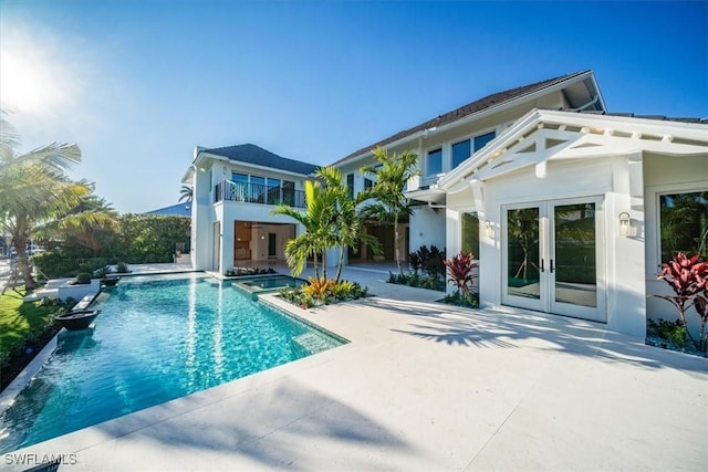back of house featuring a patio, stucco siding, an outdoor pool, french doors, and a hot tub