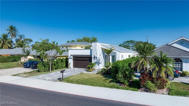 view of front of home featuring a front yard, decorative driveway, and stucco siding