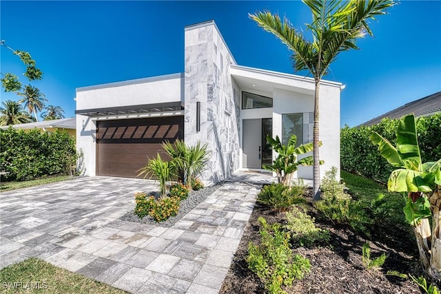 contemporary house featuring decorative driveway and stucco siding