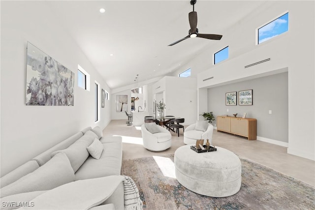 living area with recessed lighting, a high ceiling, concrete floors, a ceiling fan, and baseboards