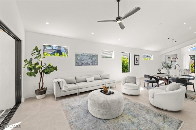 living area featuring recessed lighting, ceiling fan, and baseboards