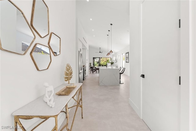 corridor featuring a towering ceiling and recessed lighting