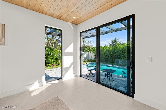 doorway to outside featuring wooden ceiling, baseboards, and recessed lighting