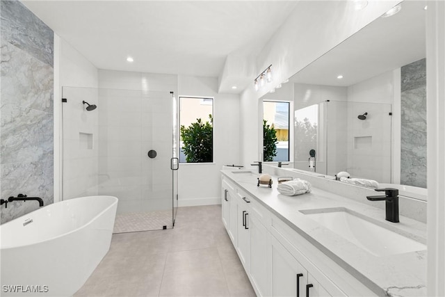 full bathroom with a soaking tub, a sink, a shower stall, and double vanity