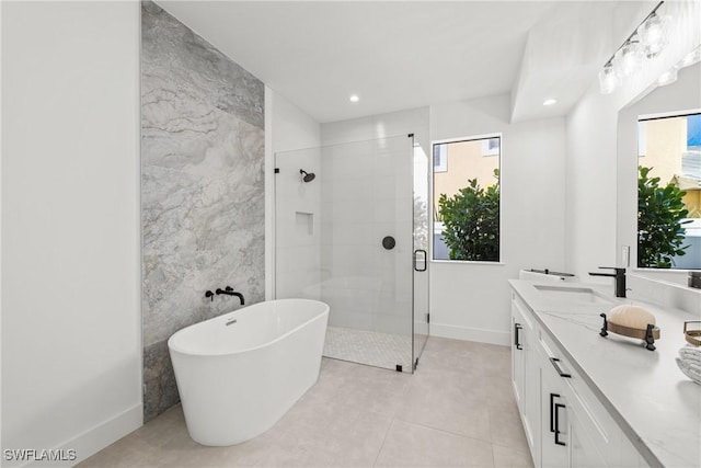 bathroom with a sink, tile walls, a soaking tub, a shower stall, and double vanity