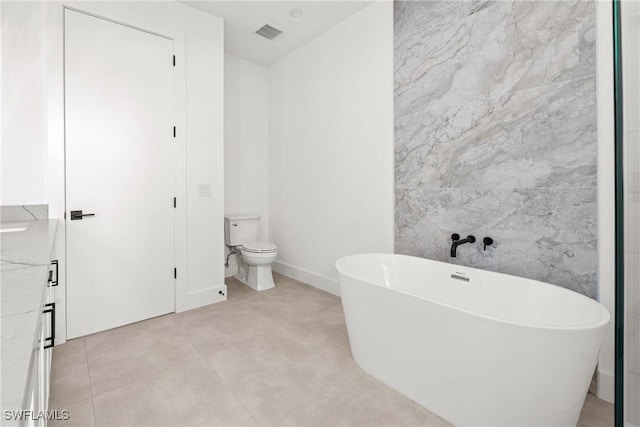 full bath with visible vents, toilet, a soaking tub, tile patterned floors, and tile walls