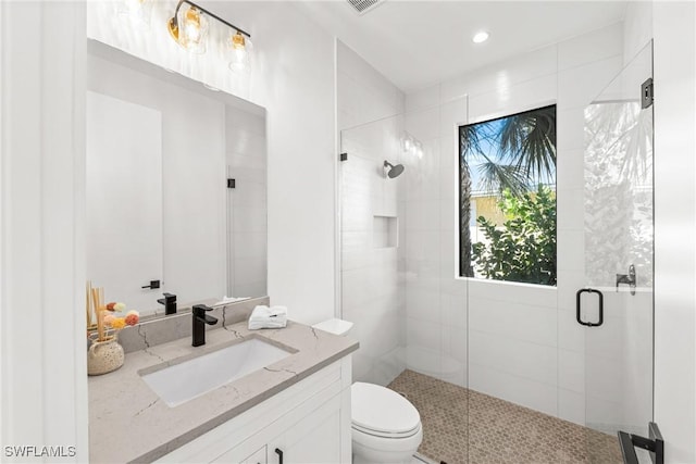 full bathroom with a stall shower, vanity, and toilet