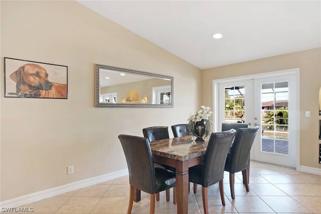 dining room with light tile floors, french doors, and vaulted ceiling