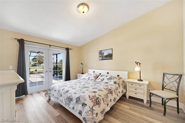 bedroom with french doors, vaulted ceiling, access to outside, and light hardwood / wood-style flooring