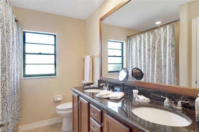 bathroom featuring toilet, tile floors, dual sinks, and large vanity