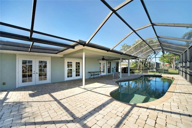 view of swimming pool with a patio area, glass enclosure, ceiling fan, and french doors