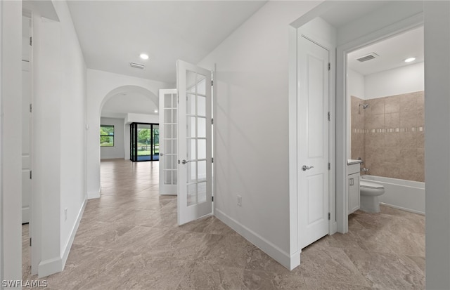 hallway featuring french doors and light tile floors