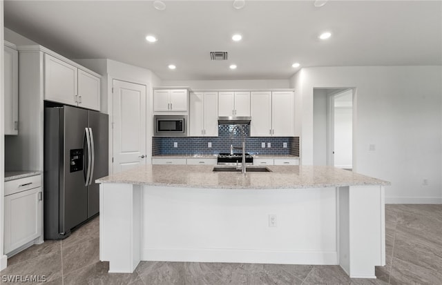 kitchen with an island with sink, stainless steel appliances, and light stone countertops