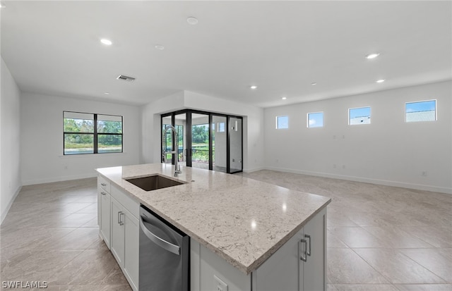 kitchen featuring sink, stainless steel dishwasher, light tile flooring, and a kitchen island with sink