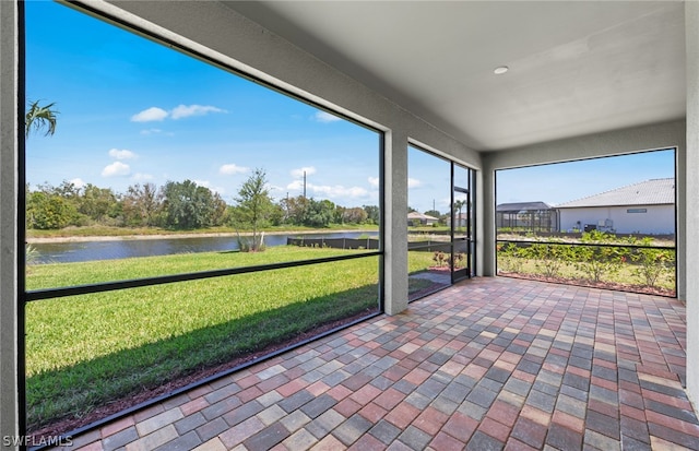 unfurnished sunroom featuring a water view