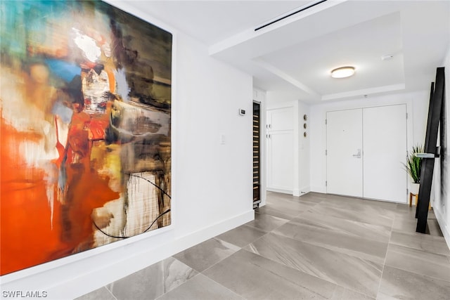 tiled entrance foyer with a raised ceiling