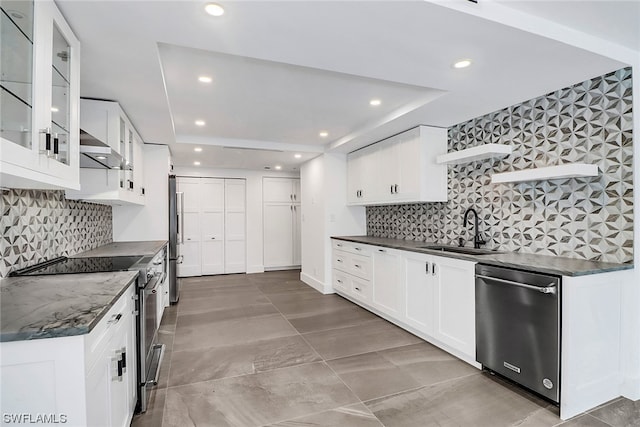 kitchen with stainless steel appliances, white cabinets, backsplash, tile flooring, and sink