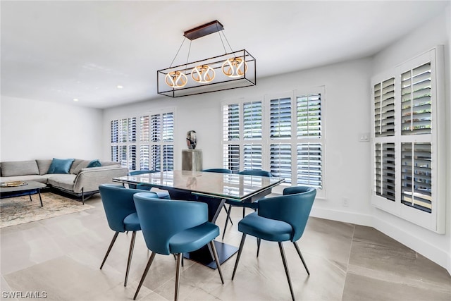 dining room with light tile floors and an inviting chandelier