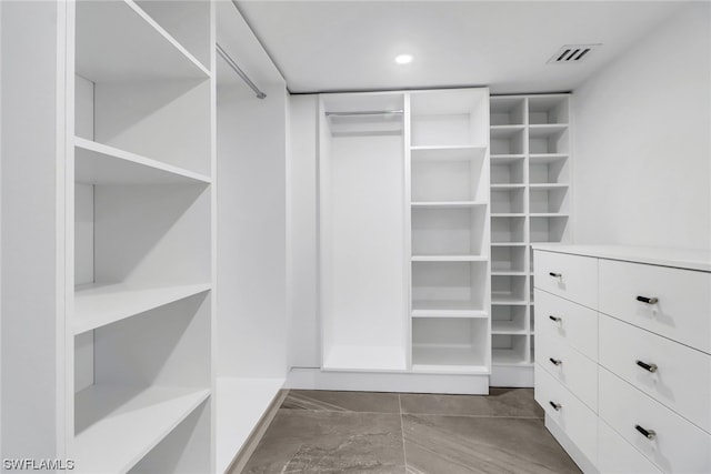 spacious closet with dark tile floors