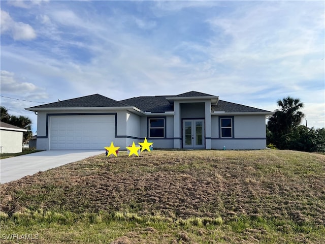 view of front of house featuring french doors, a garage, and a front lawn