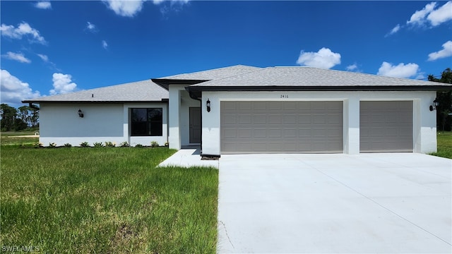 view of front of home with a front yard and a garage