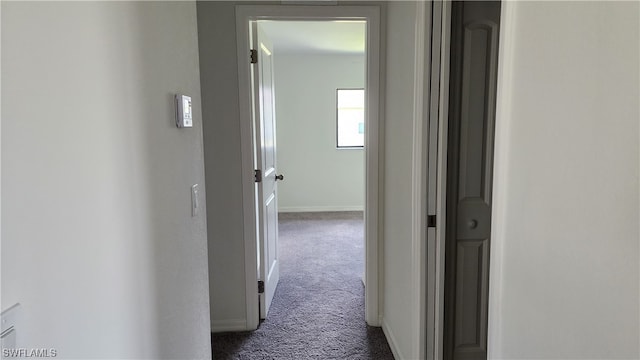 hall featuring dark colored carpet