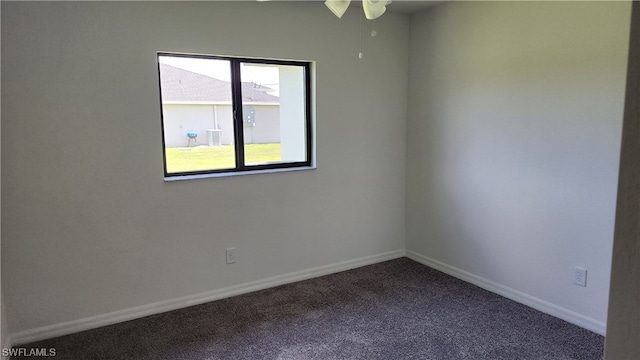 spare room featuring dark carpet