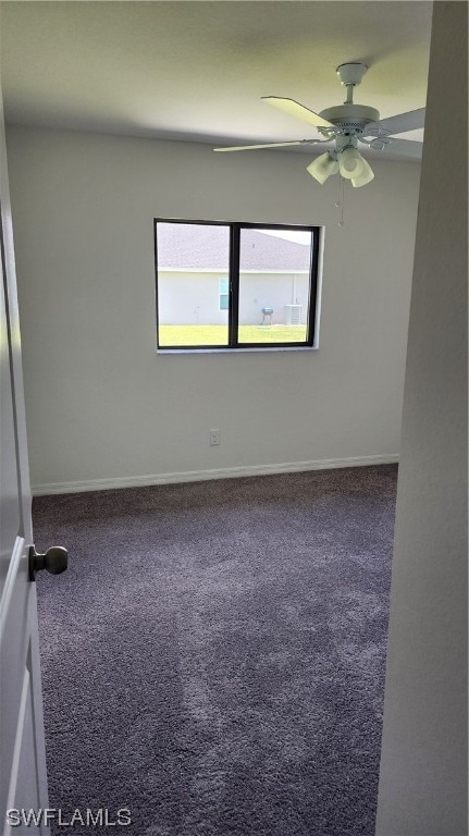 spare room with ceiling fan and dark colored carpet