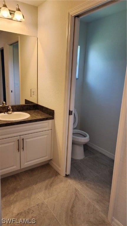 bathroom with vanity, tile flooring, and toilet