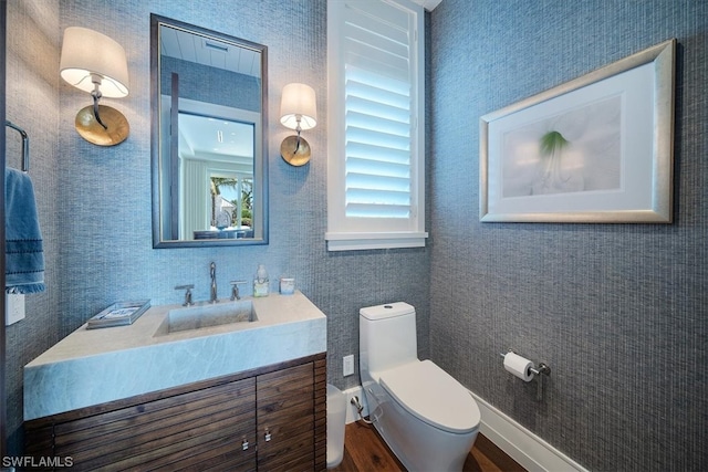 bathroom featuring vanity, wood-type flooring, and toilet