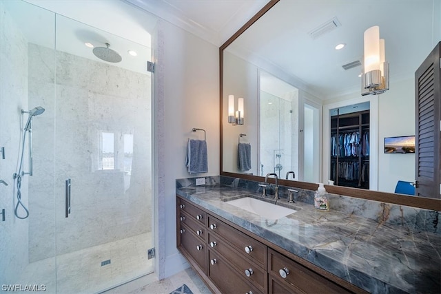 bathroom featuring a shower with door, vanity, and ornamental molding