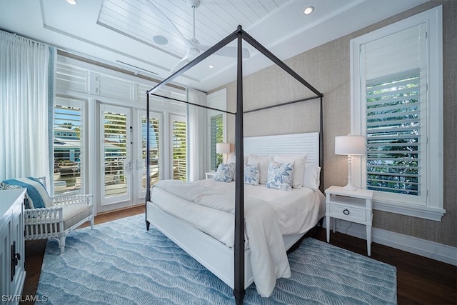 bedroom with access to exterior, hardwood / wood-style flooring, and multiple windows