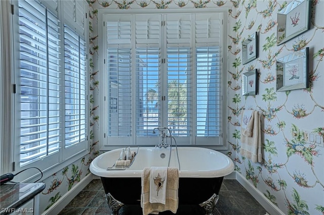 full bathroom with plenty of natural light, wallpapered walls, and baseboards