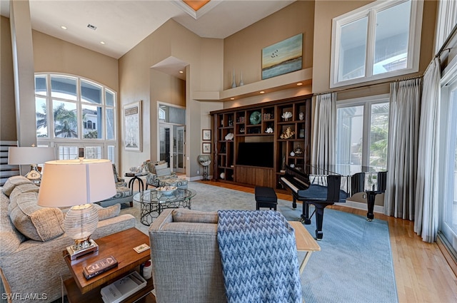 living room with a towering ceiling and light hardwood / wood-style floors