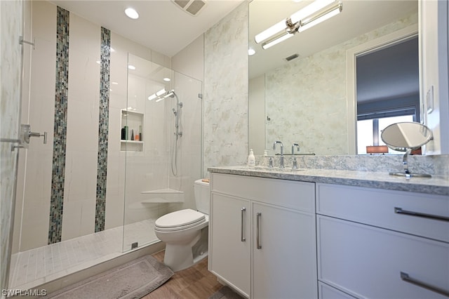 bathroom featuring hardwood / wood-style floors, vanity, an enclosed shower, and toilet