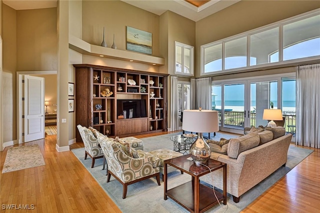 living room featuring a high ceiling, wood finished floors, and baseboards