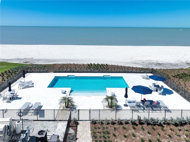 community pool featuring a patio, fence, a water view, and central AC