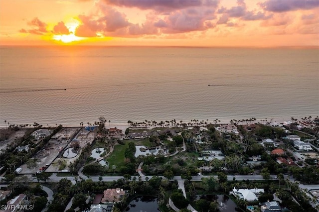 aerial view at dusk featuring a water view