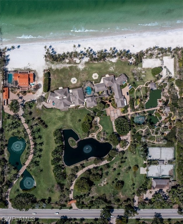 birds eye view of property with a water view and a view of the beach