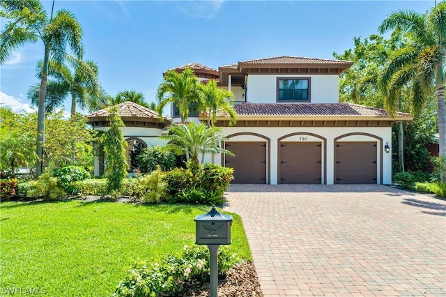 mediterranean / spanish home with a front lawn and a garage