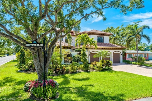 mediterranean / spanish house with a garage and a front yard