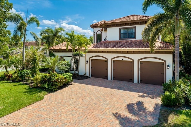 mediterranean / spanish-style home featuring a front lawn and a garage