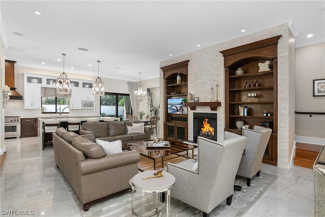 living room featuring a large fireplace, built in features, and crown molding