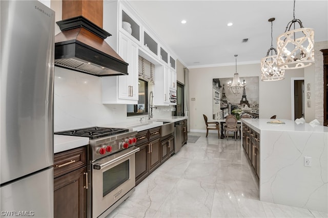 kitchen featuring custom range hood, decorative light fixtures, white cabinetry, dark brown cabinetry, and stainless steel appliances