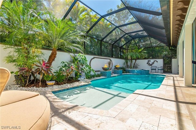 view of swimming pool featuring glass enclosure and a patio area